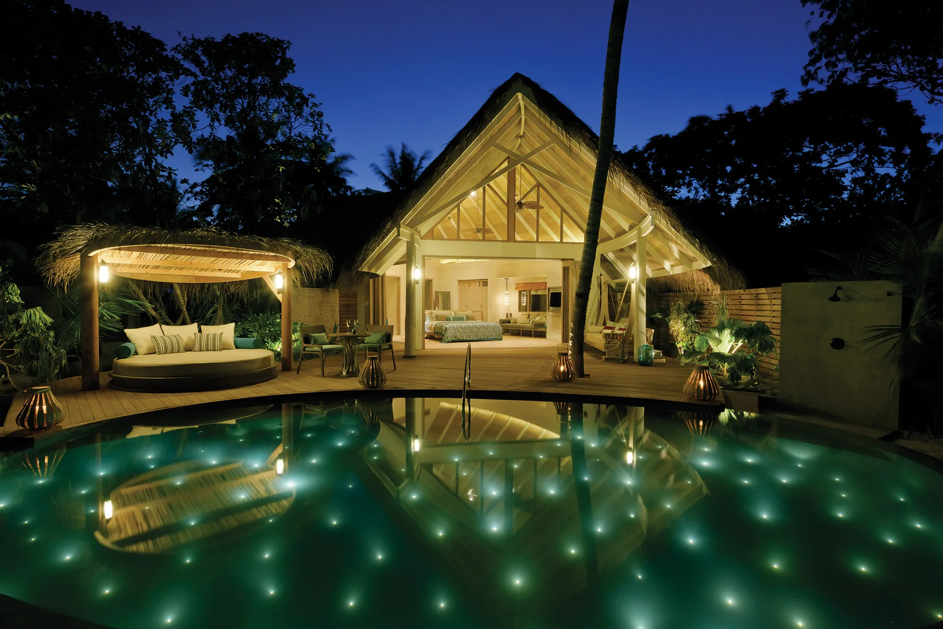 Beleuchteter Pool und Villa bei Nacht