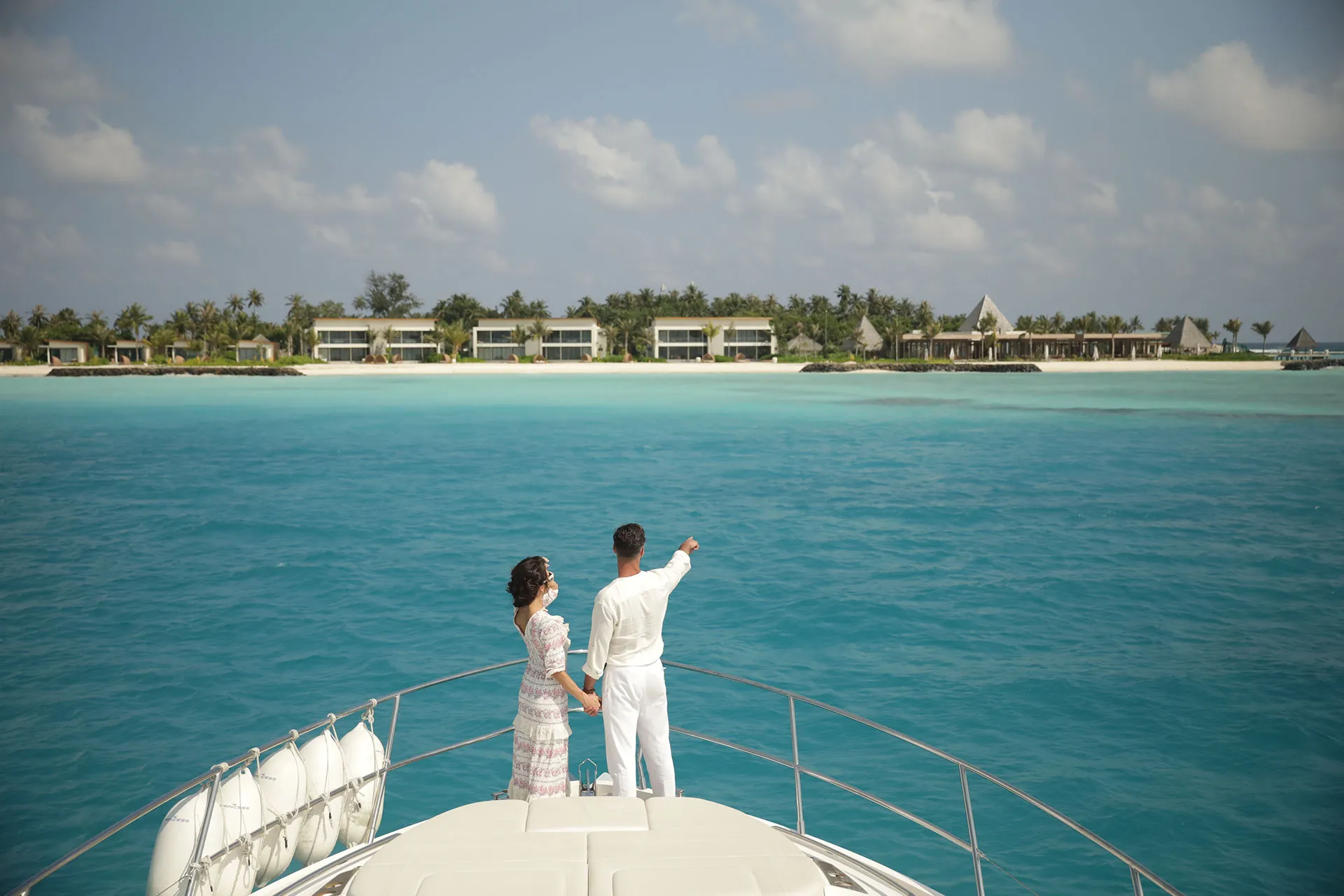 Paar auf Bootsdeck vor einer Insel